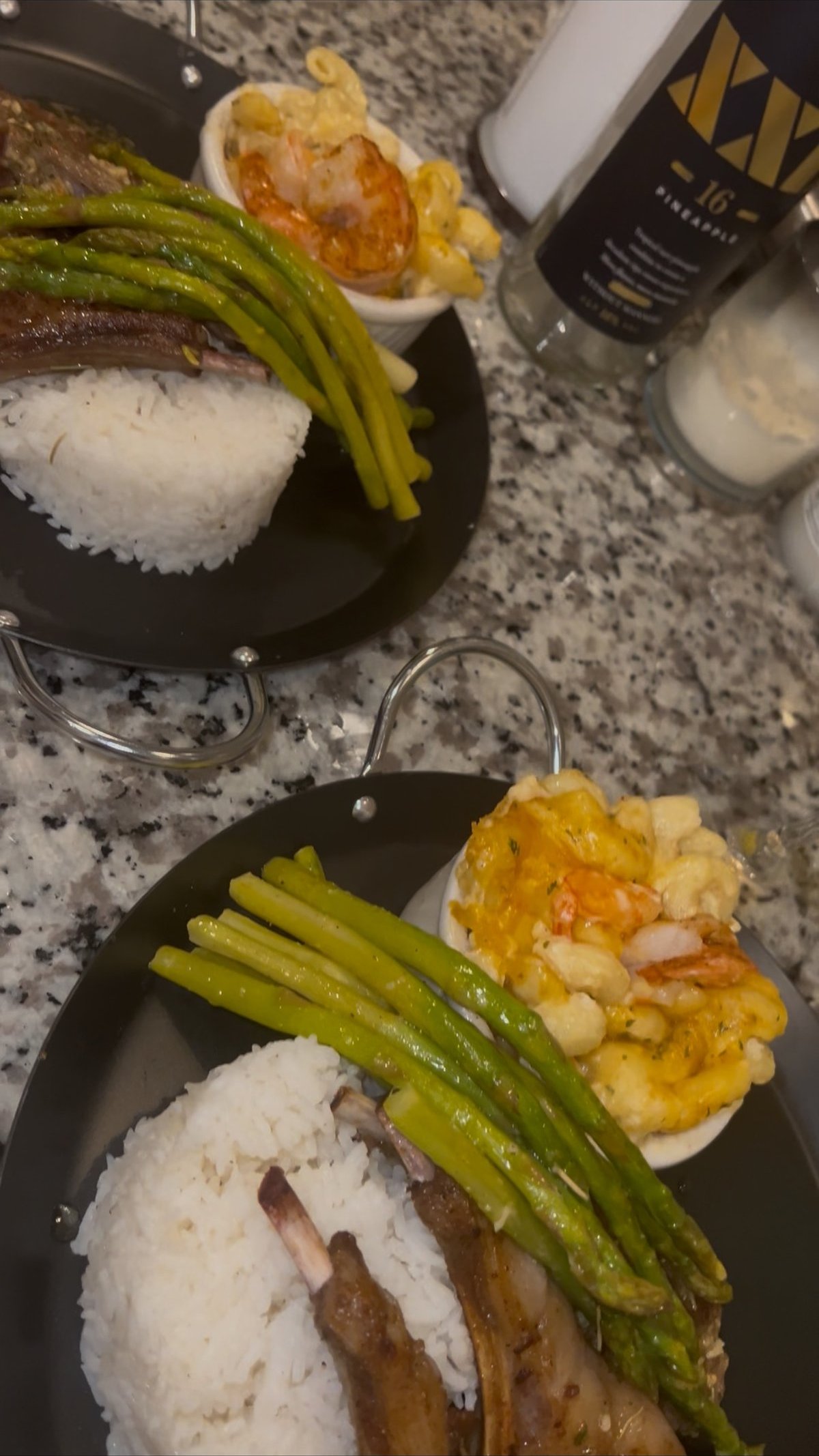 Plated lamb chops with rice, asparagus, and shrimp mac and cheese